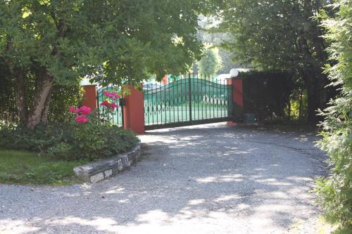 a driveway with a gate with flowers and trees at Villa Adrienne in Velden am Wörthersee