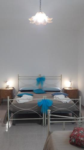a bedroom with a large bed with blue bows at Casa Le Pigne in Avola