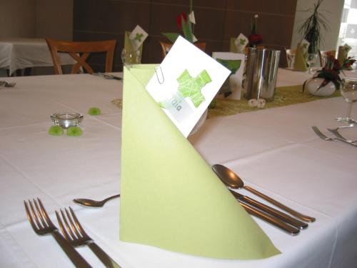 a green napkin on a table with forks and spoons at Hotel und Gasthof Ritter St. Georg in Erlangen