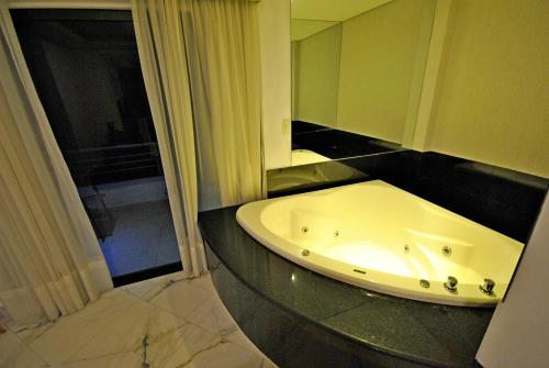 y baño con bañera y ventana. en Los Lagos Resort Hotel en Capiatá