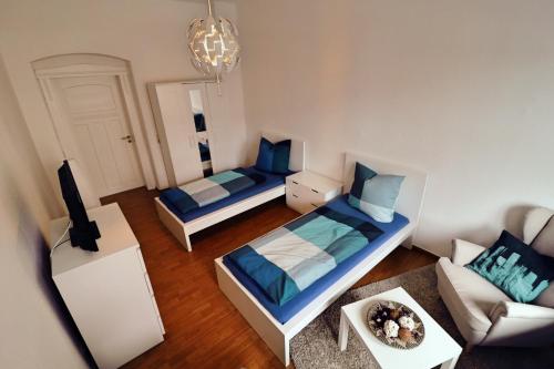 エアフルトにあるSuite an der Furtのベッド2台とソファが備わる小さな客室です。