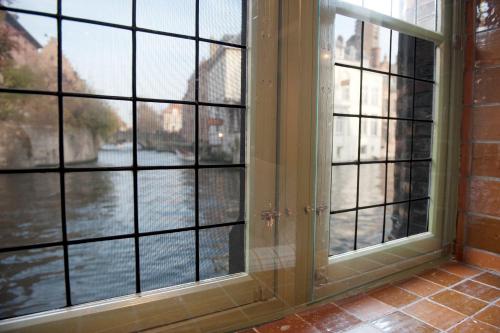 an open window with a view of a river at Hotel Bourgoensch Hof in Bruges