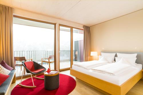 a hotel room with a bed and a balcony at Hotel Bora HotSpaResort in Radolfzell am Bodensee