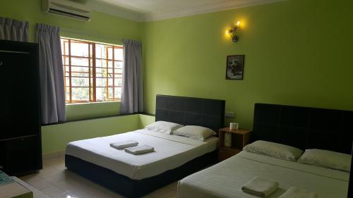 A bed or beds in a room at Borneo Gaya Lodge