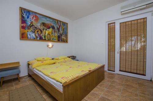 a bedroom with a bed with a painting on the wall at Apartments Jozsef in Splitska