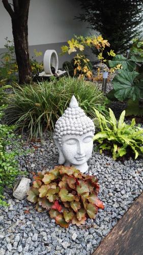 a statue of a face sitting in a garden at Gästehaus Engelgasse Herzogenaurach in Herzogenaurach