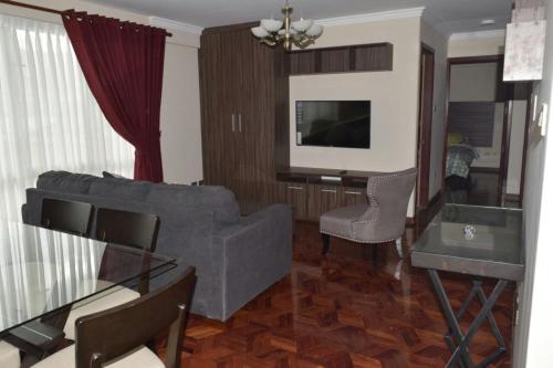 a living room with a couch and a tv at Miraflores Apart in La Paz