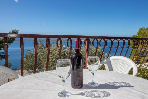 a bottle of wine sitting on a table with two glasses at Apartments Djani in Mimice