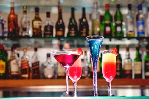 three cocktails in glasses sitting on a bar at Isango Gate in Port Elizabeth