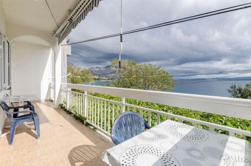 a balcony with a table and chairs and a view of the water at Apartments Anka 20m from the beach in Duće