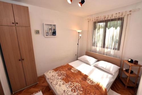 ein kleines Schlafzimmer mit einem Bett und einem Fenster in der Unterkunft Apartment Elena in Rogač