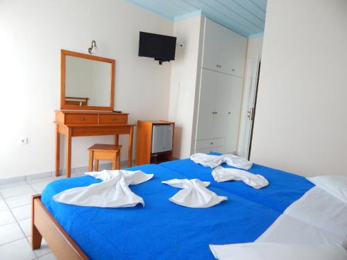 a blue bed with three white towels on it at Poseidon in Ancient Epidavros