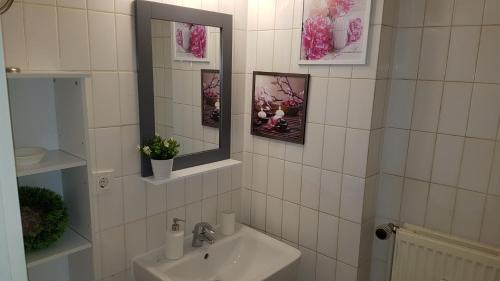 La salle de bains est pourvue de carrelage blanc, d'un lavabo et d'un miroir. dans l'établissement City Apartment, good location, à Berlin