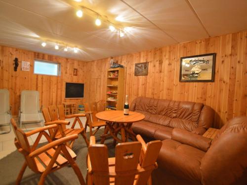 a living room with a couch and a table and chairs at Cozy Holiday Home in Robertville with Sauna in Robertville