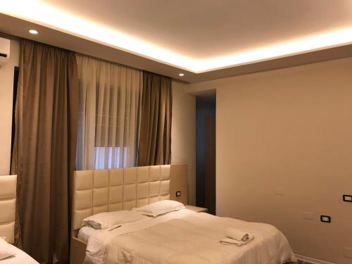 a hotel room with two beds and a window at Hotel Lungomare in Vlorë
