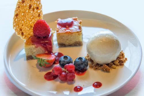 a plate of desserts with fruit and ice cream at Hotel et le Cafe de Paris in Apeldoorn