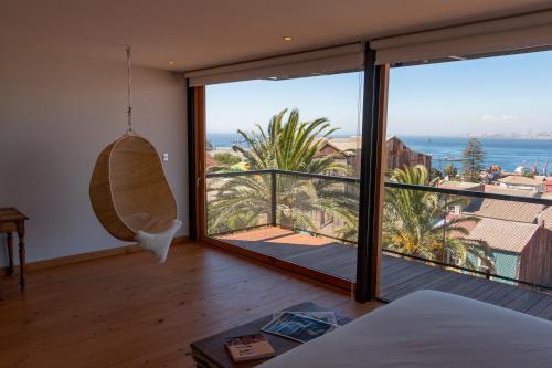 a bedroom with a large window with a view of the ocean at Augusta Hotel in Valparaíso