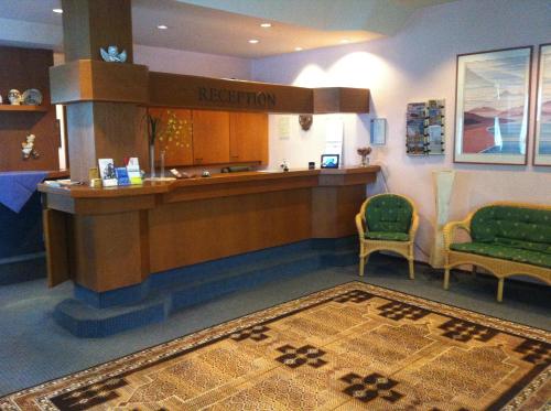a lobby with a reception desk and two chairs and a rug at Hotel Kelkheimer Hof in Kelkheim