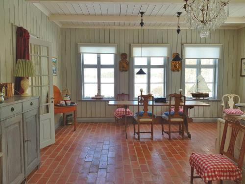 a dining room with a table and chairs and windows at Ängbacka in Rejmyre