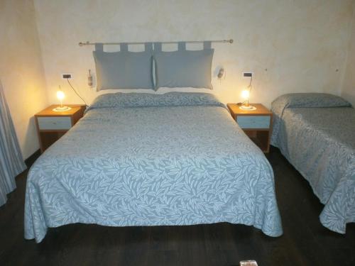 a bedroom with a bed and two lamps on tables at Albergo Vecchio Pavone in Borgaro Torinese