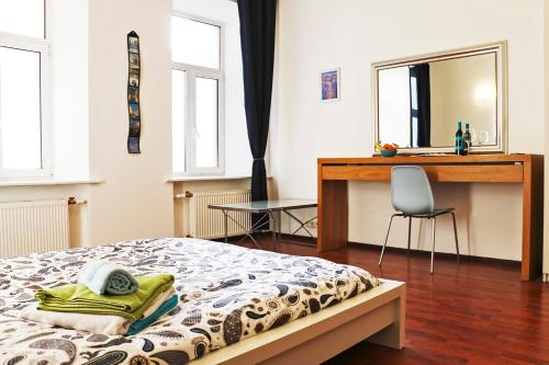a bedroom with a bed and a desk and a chair at La Casa Di Bury Apartments 1 in Saint Petersburg