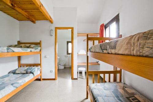 a room with two bunk beds and a bathroom at L'Orri del Pallars in Montardit