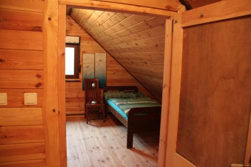 Habitación pequeña con 1 cama en una cabaña de madera en Winnica Dębogóra en Woldenberg Neumark