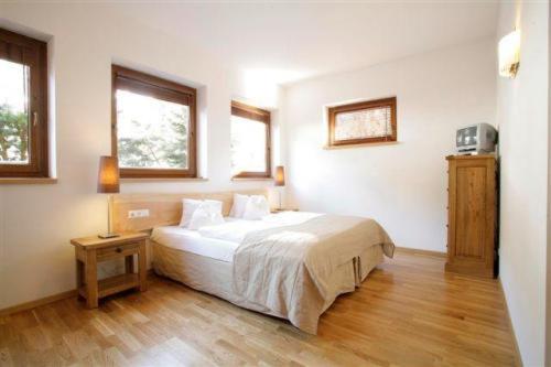 a bedroom with a large bed and two windows at Appartement Seeland in Weissensee