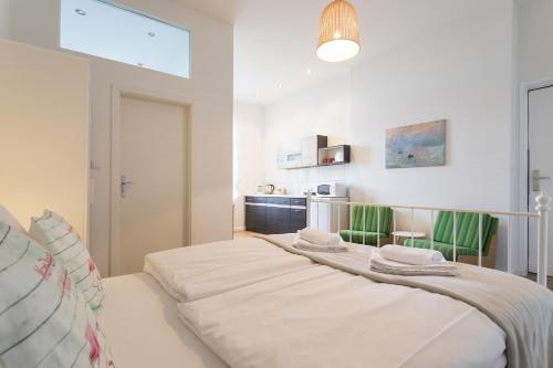 a bedroom with a large white bed with green chairs at Stylish & Cosy Apartment in Berlin, WiFi in Berlin