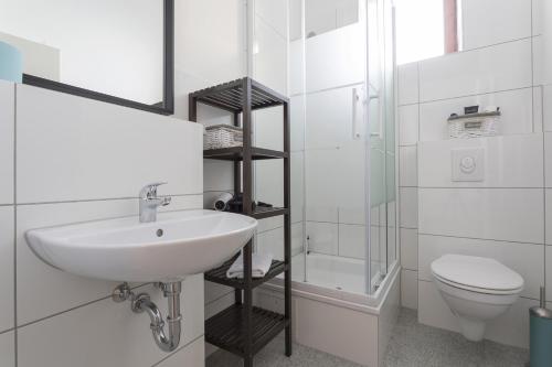 a white bathroom with a sink and a toilet at Stylish & Cosy Apartment in Berlin, WiFi in Berlin