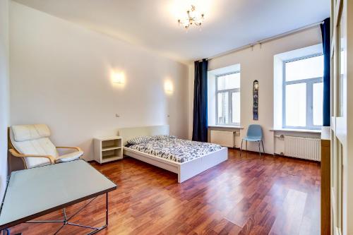 a bedroom with a bed and a table and two chairs at La Casa Di Bury Apartments 1 in Saint Petersburg