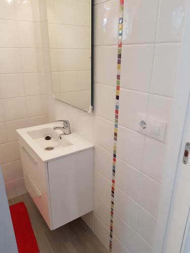 uma casa de banho branca com um lavatório e um espelho em Casita en TUY /TOMIÑO em Tui