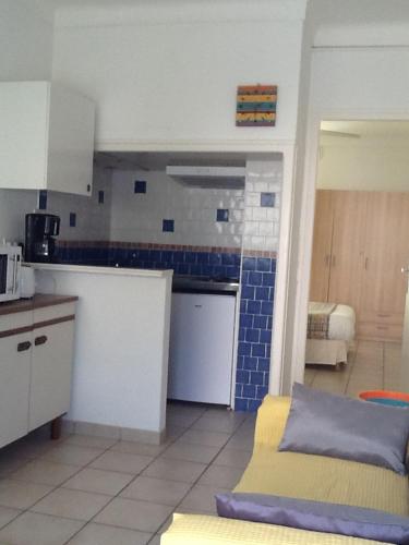 - une cuisine avec du carrelage bleu sur les murs dans l'établissement Locations Meublées Plage des Pins, à Argelès-sur-Mer