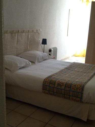アルジェレス・シュル・メールにあるLocations Meublées Plage des Pinsのベッドルーム1室(大型ベッド1台、白いシーツ、枕付)