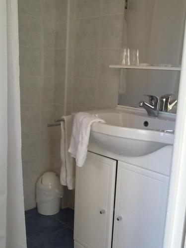 une salle de bain avec un lavabo blanc et un miroir dans l'établissement Locations Meublées Plage des Pins, à Argelès-sur-Mer
