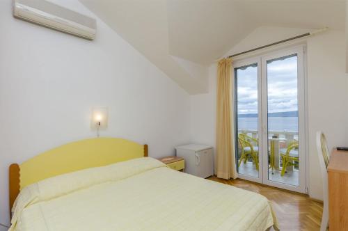 a bedroom with a bed and a large window at Apartment and Rooms Mate in Bol