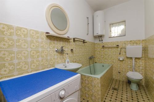 a bathroom with a sink and a toilet and a mirror at House Fanita in Splitska