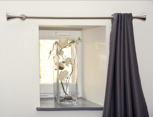 a mirror with a vase with flowers in it at Gite le murger in Meursault