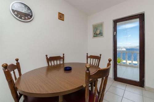 a dining room with a table and a clock on the wall at Apartment Barba in Rogač