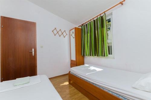 a small bedroom with two beds and a window at House Barbarina in Rogač