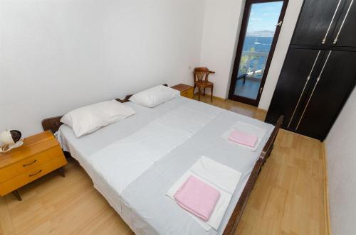 a bedroom with a large bed with pink pillows on it at Apartment Barba in Rogač