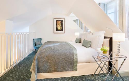 a bedroom with a large bed and a staircase at Le Burgundy Paris in Paris