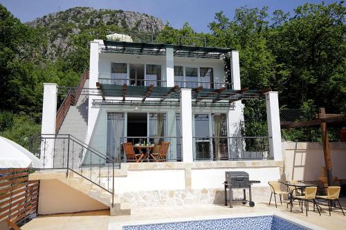 a white house with a balcony and a swimming pool at Apartments Oktopus in Sutomore
