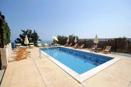 a swimming pool with lounge chairs and a swimming pool at Apartments Oktopus in Sutomore