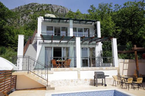 a white house with a balcony and a swimming pool at Apartments Oktopus in Sutomore