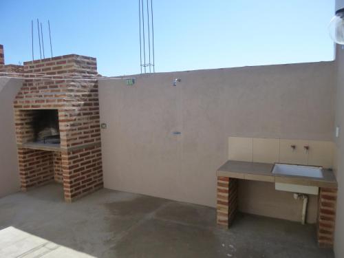 a patio with a brick fireplace and a table at Sendero Patagonico in Las Grutas
