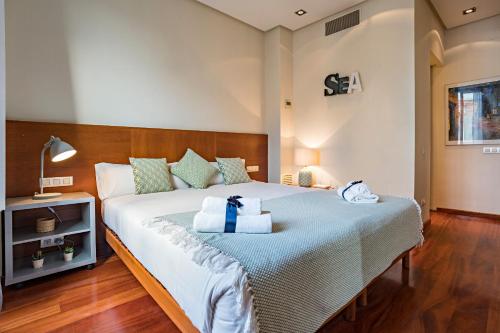 バルセロナにあるHabitat Apartments Paseo de Gracia Suiteのベッドルーム1室(青いリボン付きのベッド1台付)