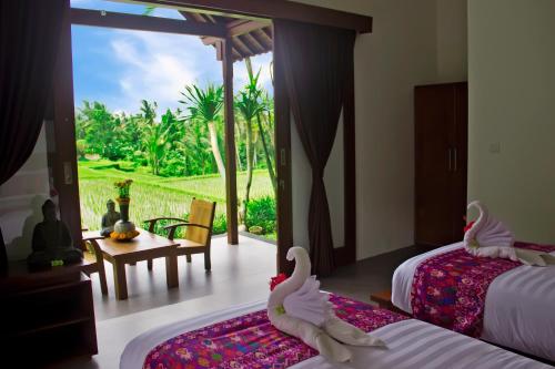 a bedroom with two beds with swans on the beds at Villa Kicen Ubud in Ubud