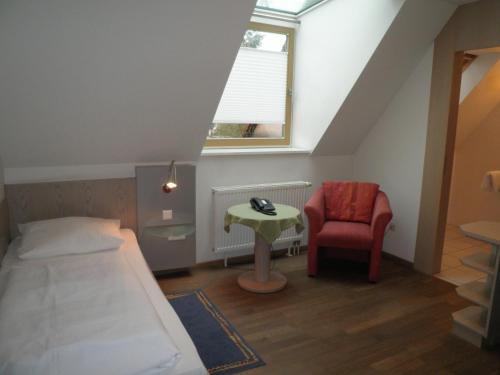 a small room with a bed and a chair at Hotel und Gasthof Ritter St. Georg in Erlangen