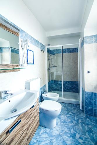 a bathroom with a toilet and a sink and a shower at Hotel Centro in Torre Pellice